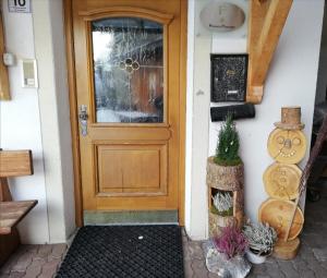 uma porta de madeira numa casa com plantas em Zimmer - Hinterwalderhof em Mühlbach