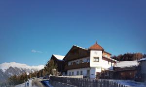 a building with a fence next to a road at Zimmer - Hinterwalderhof in Mühlbach
