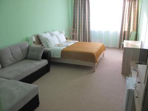 a hotel room with a bed and a couch at Bolshoy Ural na Stachek Hotel in Yekaterinburg