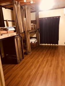a room with wooden floors and a black curtain at Matsue Guesthouse in Matsue