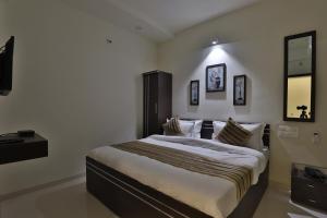 a bedroom with a large bed in a room at Hotel Nova Havana in Rajkot