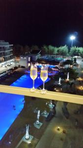 two wine glasses sitting on a ledge next to a pool at Grandblue condominium 609 in Mae Pim