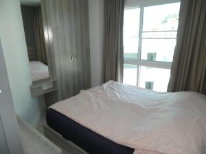 a small bedroom with a bed with a window at Grandblue condominium 609 in Mae Pim