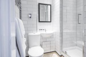 a white bathroom with a toilet and a sink at The Old Gate Inn by Innkeeper's Collection in Canterbury