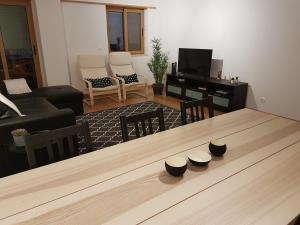 een woonkamer met een tafel met stoelen en een televisie bij Quinta dos Lombos in Carcavelos