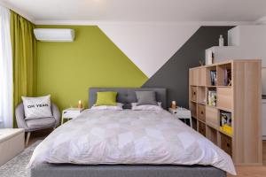 ein Schlafzimmer mit einem Bett und einer grünen Wand in der Unterkunft The Spot - fully equipped, central, modern studio by Flat Mаnager in Sofia