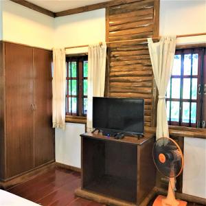 a living room with a flat screen tv on a table at Utopia House Phangan in Mae Haad