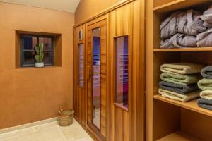 a bathroom with a closet with towels and a mirror at De Kaleihoeve in Bavikhove