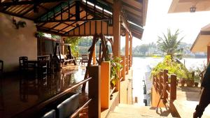 un restaurante con vistas al río y a un edificio en Tamarind Guesthouse en Kanchanaburi