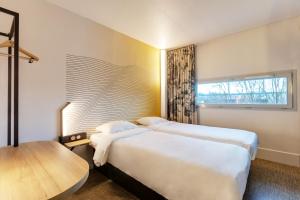 a hotel room with a large bed and a window at B&B HOTEL Lille Centre Grand Palais in Lille