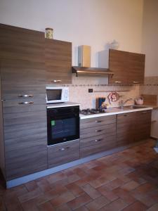 La cuisine est équipée de placards en bois et d'un four avec plaques de cuisson. dans l'établissement Agriturismo Tre Madonne, à Monteriggioni