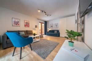 salon z niebieskim krzesłem i kanapą w obiekcie RentPlanet - Apartamenty Szrenica w Szklarskiej Porębie