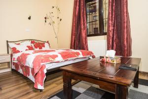 een slaapkamer met een bed en een houten tafel bij Motor House Unirii in Boekarest
