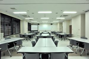 an empty classroom with white tables and chairs at Refre Forum in Tokyo