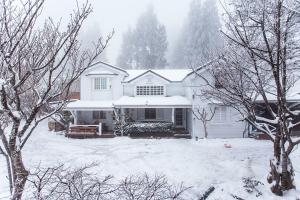 a white house with snow on top of it at He Feng Homestay in Hualing