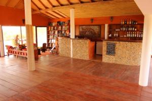 ein Wohnzimmer mit Holzboden und eine Küche in der Unterkunft Le Lodge Dalaal Diam in Somone