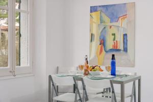 un comedor con una mesa con sillas y una pintura en Sa Tuna 1- Cal Guarda, en Begur