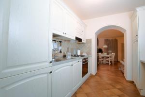 a kitchen with white cabinets and a dining room at Il balcone di Angelina in Isola del Liri