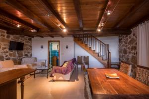 a living room with a wooden table and a staircase at O Canto da Terra in Pantón