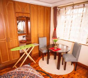 a small room with a table and chairs and a window at Sherry Homes - Kwetu in Nairobi