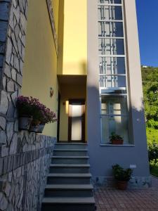 ein gelbes Haus mit einer Treppe und einem Fenster in der Unterkunft Guest house Il Giardino in Città in La Spezia