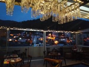 un restaurante con lámparas de araña y vistas a la ciudad en Sakura Suit Hostel, en Fethiye