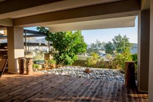 an open patio with a large window and a rock garden at Relux Apartment in Agios Nikolaos