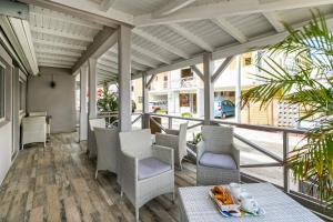 a porch with chairs and a table with a tray of food on it at Hevea Hotel in Grand Case