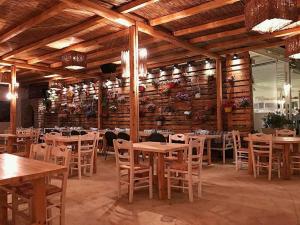 a restaurant with tables and chairs in a room at Cactus Beach Paros in Logaras