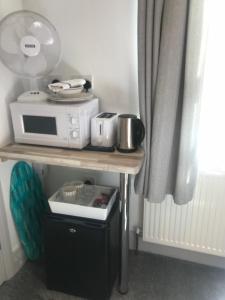 a table with a microwave on top of it at The Lake House in Plymouth