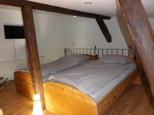 un letto con struttura in legno in una stanza di Zum Sudhaus im Herzen der Schorfheide a Golzow