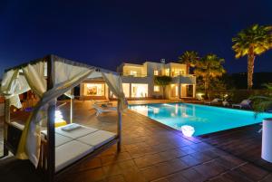 a villa with a swimming pool at night at Villa Can Fluxa in Ibiza Town