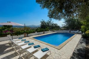 a swimming pool with lounge chairs and an umbrella at Villa Torre Bes in San Antonio