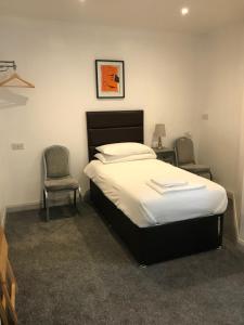 a bedroom with a bed and two chairs in it at The Lake House in Plymouth