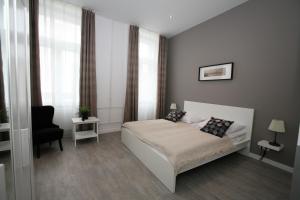 a small bedroom with a bed and a chair at CENTER rooms in Miskolc