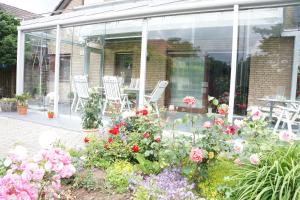 giardino d'inverno con sedie e fiori di Apartmentvermietung Meerbusch a Meerbusch
