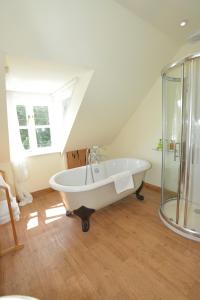 a bathroom with a white bath tub in a attic at Althea House with parking in Padstow