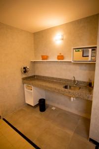 a small kitchen with a sink and a microwave at Pousada Encantare in Aracaju