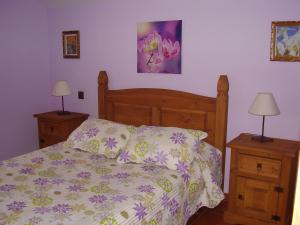 1 dormitorio con 1 cama y 2 mesas con lámparas en El Magnolio, en Santillana del Mar