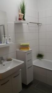 y baño con lavabo, bañera, aseo y lavamanos. en Fewo Kroker, en Bremerhaven
