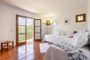 a hotel room with two beds and a balcony at Villa Patri in Sant Carles de Peralta