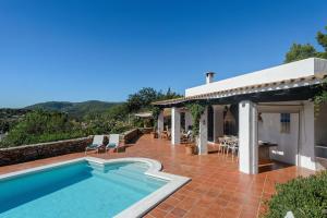 a house with a swimming pool and a patio at Villa Patri in Sant Carles de Peralta