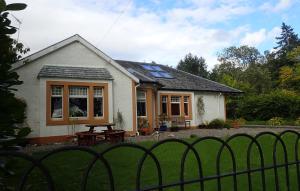 a house with a picnic table in front of it at Arrochoile in Balmaha