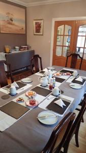 una mesa de comedor con platos y platos. en Arrochoile, en Balmaha