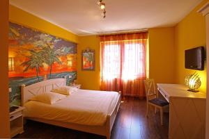 a bedroom with a bed and a desk and a television at Hotel Champ Alsace in Haguenau