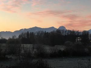 einen Sonnenuntergang mit Bergen im Hintergrund in der Unterkunft Ferienwohnung Bergblick in Bad Aibling