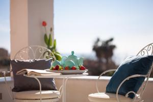 einen Tisch mit einer Teekanne und einem Obstteller darauf. in der Unterkunft Casa Vacanze Eco del Mare in Agrigento