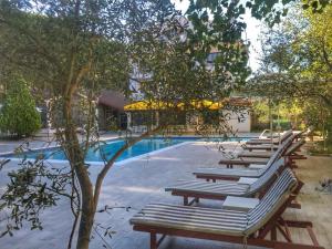 una fila di sedie a sdraio accanto alla piscina di Hotel Pishat e Buta a Golem Altre 36 foto