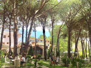 un gruppo di persone sedute in un parco con alberi di Hotel Pishat e Buta a Golem