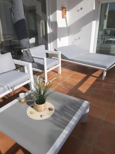 エステポナにあるAlcazaba Lagoon Estepona Golfのリビングルーム(白い椅子、テーブル付)